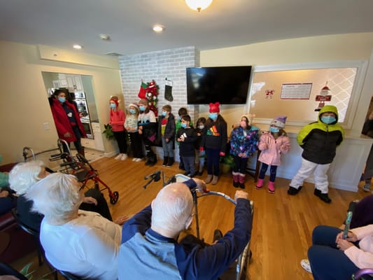 Children performing in front of assisted living residents