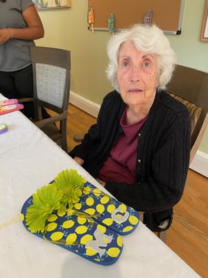 Resident engaging in a craft activity with flip flops