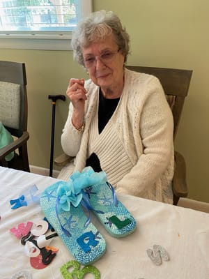 A resident decorating flip-flops during an activity