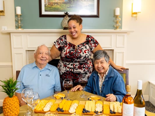 Residents enjoying a meal with staff in a warm setting