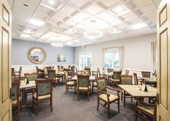 Dining room with tables and chairs arranged for residents