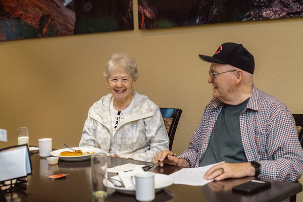 Two residents enjoying a meal in a dining area