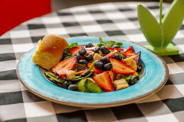 A colorful salad with strawberries and blueberries on a plate