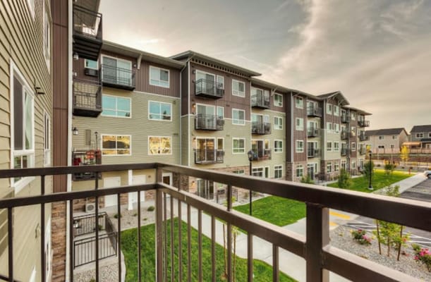 View of a residential building with balconies and green space