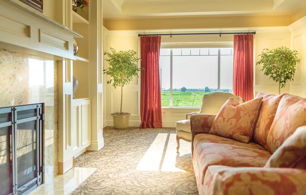 Bright common area with large window and floral couch