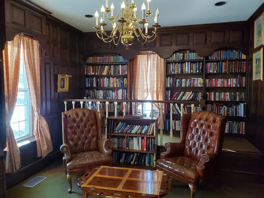 Cozy library area with bookshelves and leather chairs