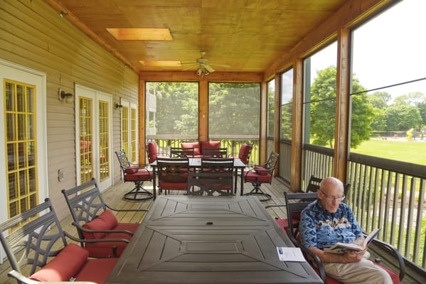 A resident reading on a screened porch