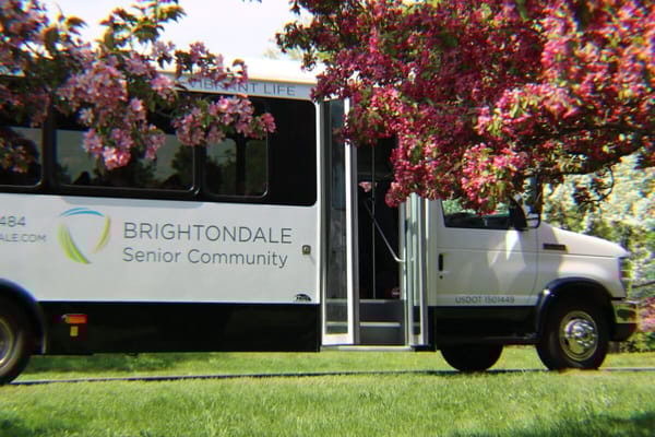 Facility transport van parked near blooming tree