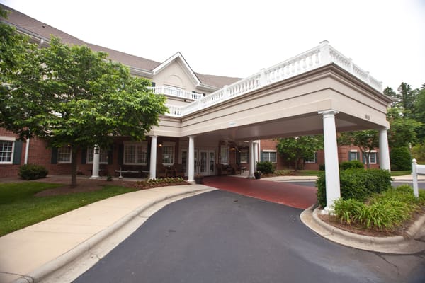 Building entrance with a covered walkway and greenery