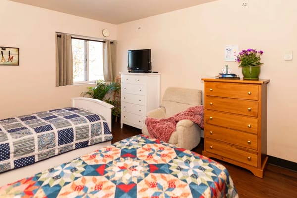 Bedroom with two beds, a chair, and a dresser