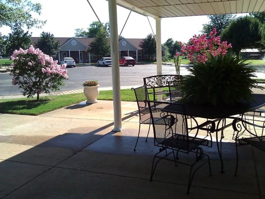 Outdoor seating area with flowers and parking lot