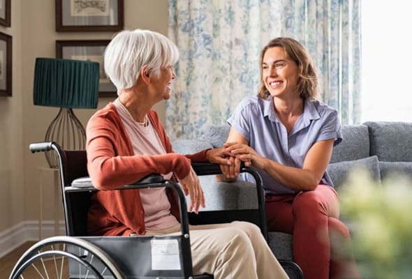 A caregiver and a senior woman sharing a moment in a living space