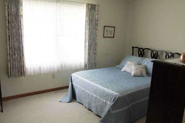 A cozy resident room with a bed and natural light