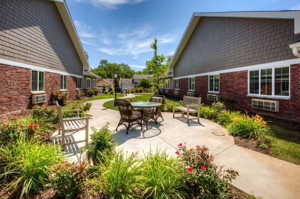 Beautiful courtyard with seating and gardens at Edencrest at Green Meadows.