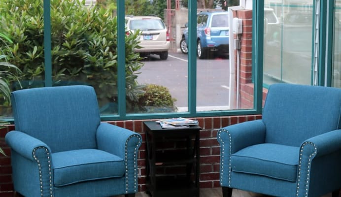 Seating area with blue chairs beside a glass wall