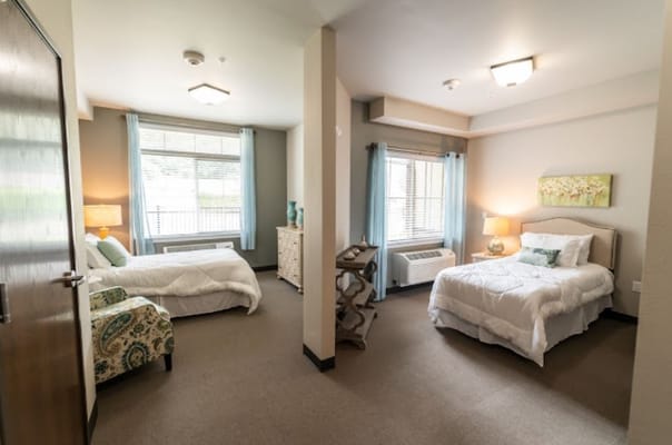 A spacious shared bedroom in a senior living facility