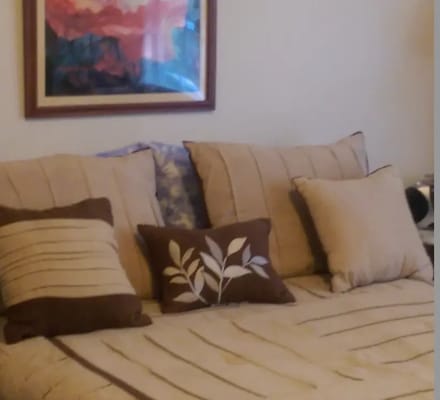 A neatly made bed with decorative pillows in a cozy bedroom.