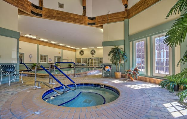 Indoor pool area with spa and seating