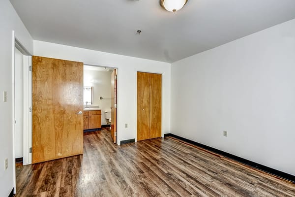 Empty room with wooden floors and adjoining bathroom