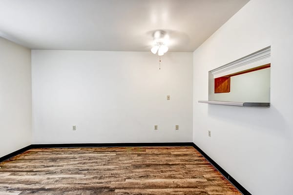 View of an empty room with wood flooring and a ceiling fan