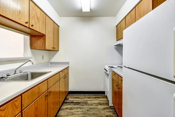 A modern kitchen featuring wooden cabinets, a sink, and appliances.