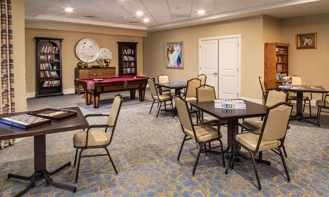An interior activity room with tables and chairs