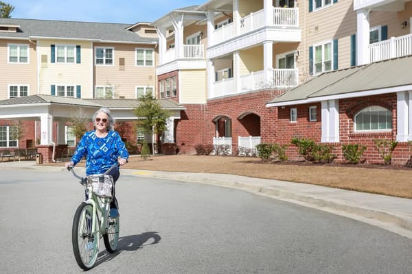 Resident riding a bicycle in front of the facility