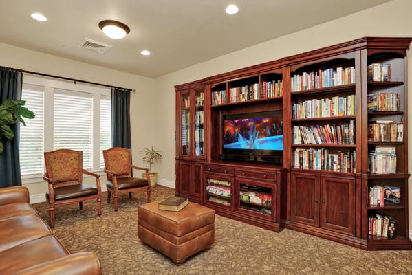 Lounge with bookshelves, sofa, and chairs in Highland Glen