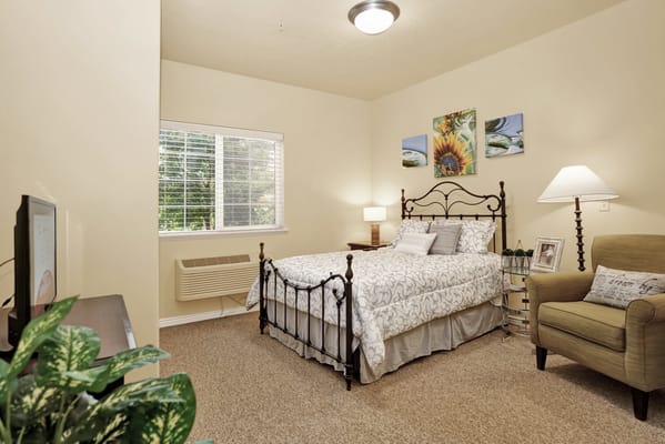 Bright and inviting bedroom with a bed, armchair, and window.