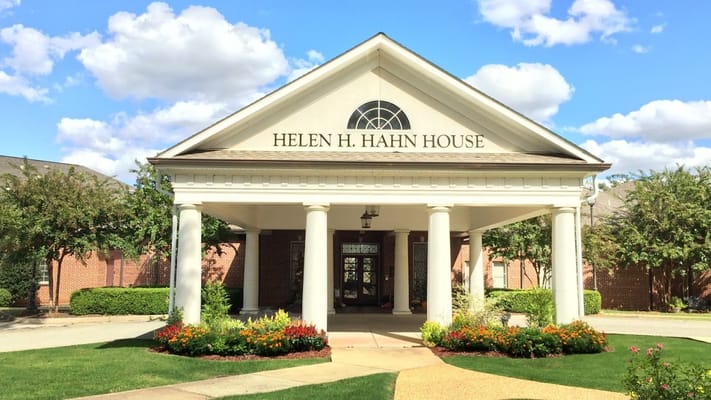 Front view of Helen H. Hahn House with colorful flowers and clear blue sky