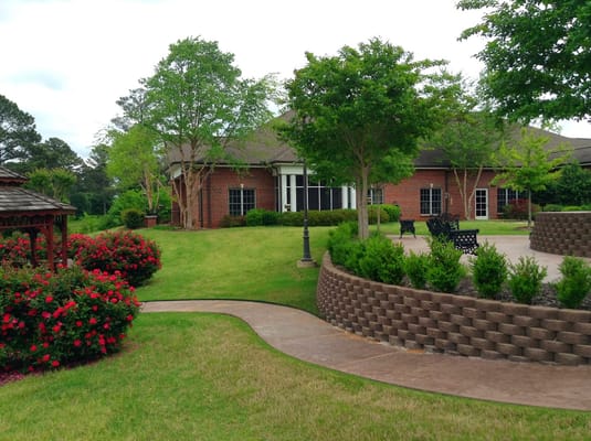 Well-maintained garden with flowers and seating at Hospice of West Alabama.