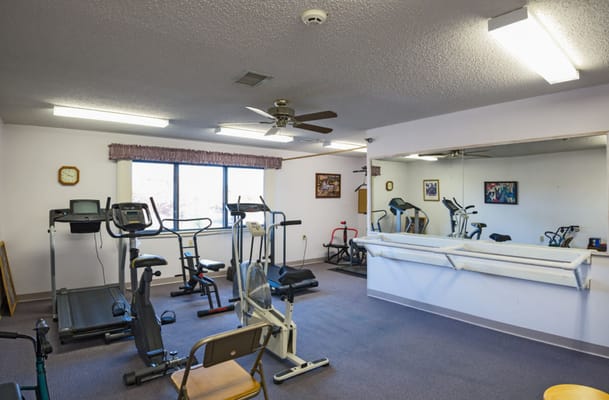 Facility exercise room with fitness equipment and large window