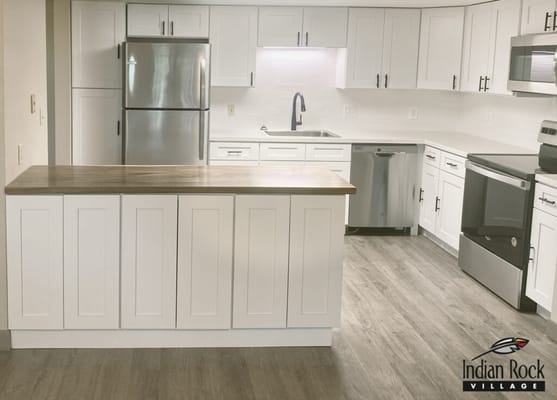 Bright kitchen area with modern appliances and logo