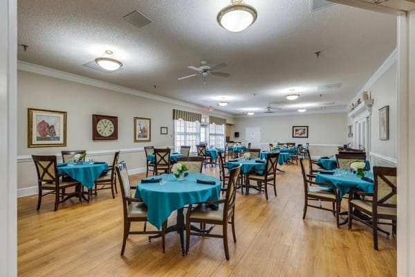 Spacious dining area with teal tables and wooden chairs