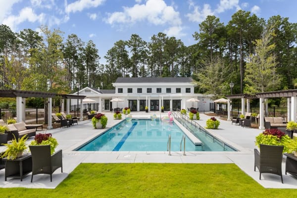 Outdoor pool area with lounge seating and greenery