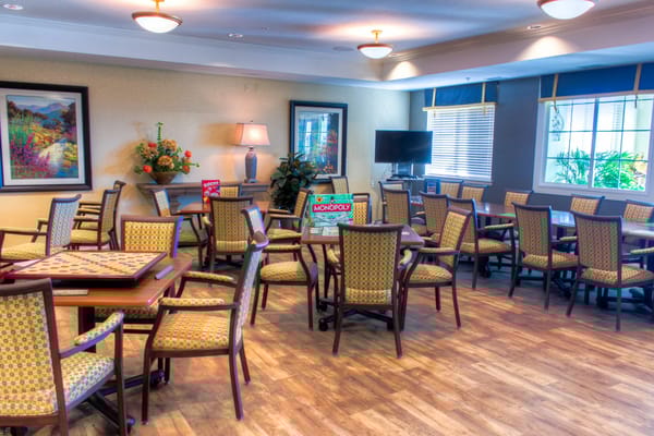 Seating area with tables and games in Peakview Assisted Living.