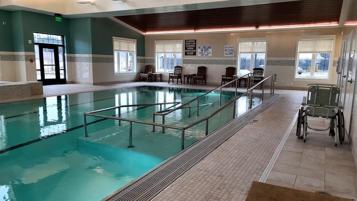 Indoor pool area with mobility aids and seating