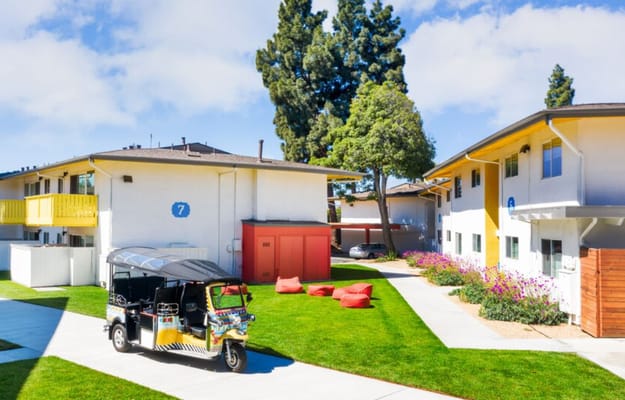 Outdoor space featuring vibrant gardens and a facility vehicle