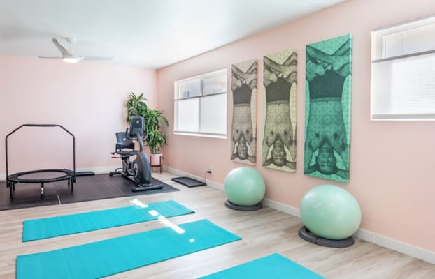 Bright fitness room with exercise equipment and mats