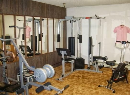 Fitness equipment in a gym with mirrors and exercise bikes