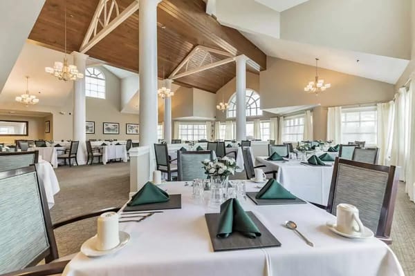 Dining room with elegantly set tables and flowers