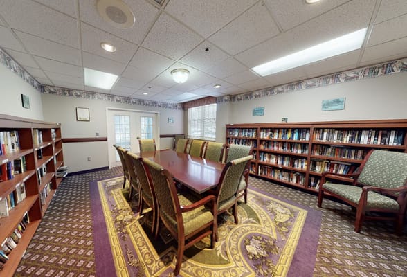 Common area with a long conference table and bookshelves
