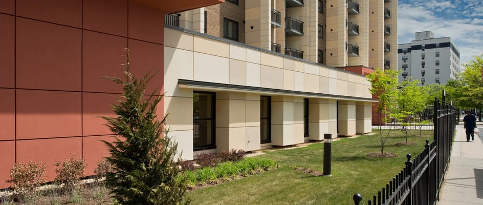 Modern building exterior with landscaped garden at Samuel J. Simmons NCBA Estates.
