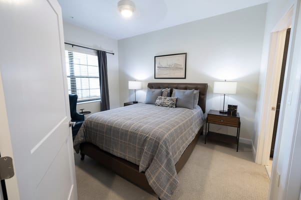 Bright, well-furnished resident room with a bed and nightstands.
