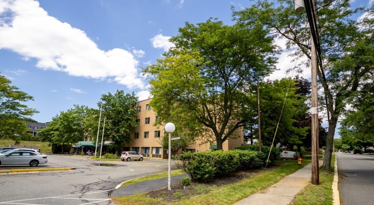 View of the exterior of Waterview Villa with trees and parking