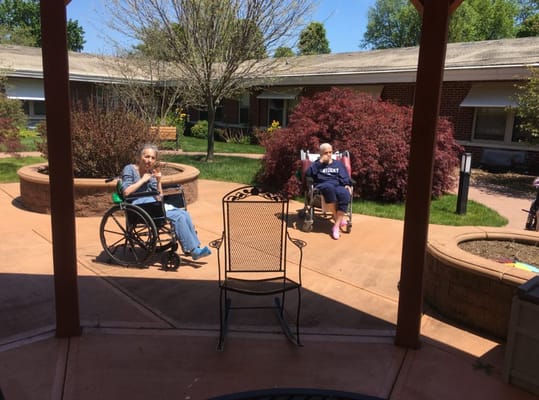 Two residents enjoying the sunny patio area.