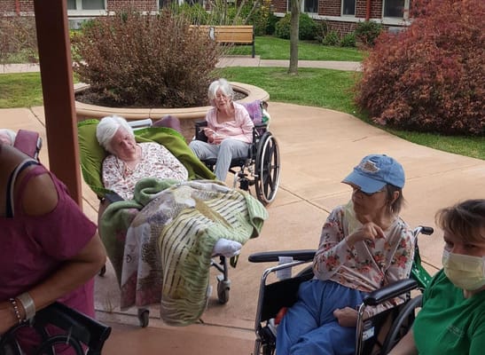 Four residents in wheelchairs relaxing outside