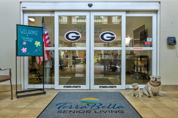 Main entrance with a welcome sign and decorative bulldog statues