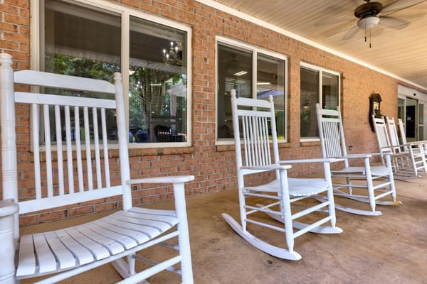 White rocking chairs lined up on a porch