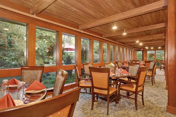 Dining area with large windows overlooking greenery